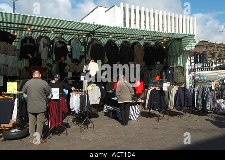 Shoppers portant des manteaux d'hiver à l'échoppe de marché pour la vente de vêtements de visualisation Romford street market place London Borough of Havering East London England UK Banque D'Images