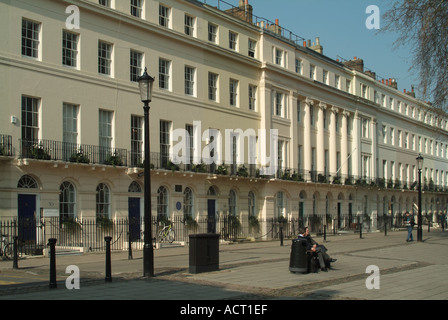 Personnes assises à Fitzroy Square avec la façade Robert Adams dont une résidence de George Bernard Shaw et Virginia Stephen London Angleterre Banque D'Images