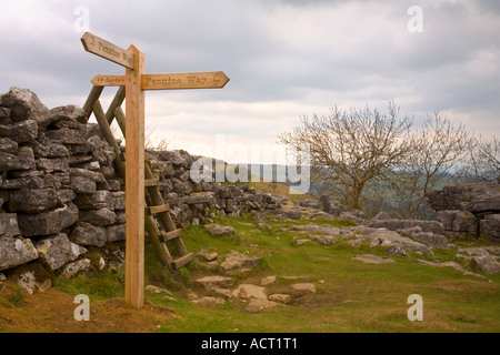 Un nouveau panneau en bois sur le Pennine Way, dans le Yorkshire, Angleterre à Malham Cove Randonneurs visible dans la distance Banque D'Images