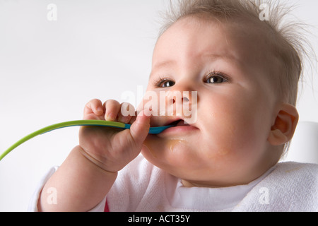 Bébé joufflu de manger une cuillère Banque D'Images
