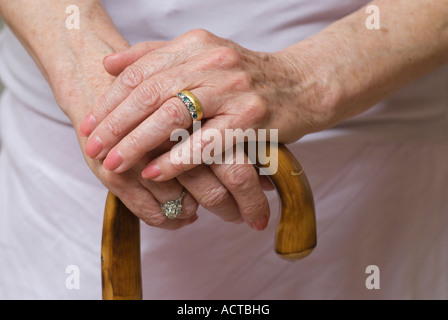 Une vieille femme mains reposant sur un bâton de marche ou de cannes Banque D'Images