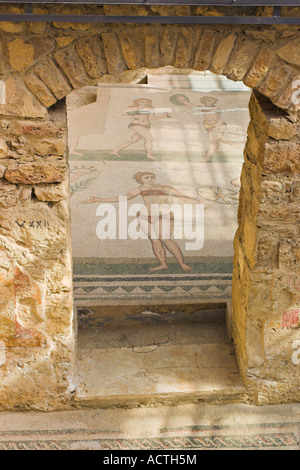 Poser une beauté bikini clad girl pose dans une mosaïque encadré par une porte de pierre massive Banque D'Images