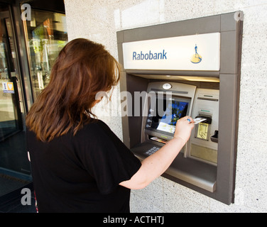 Femme à l'aide d'une machine à cash Rabobank aux Pays-Bas Banque D'Images