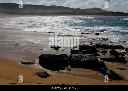 Des roches de lave noire sur la plage de 3 miles Moomomi Molokai Banque D'Images