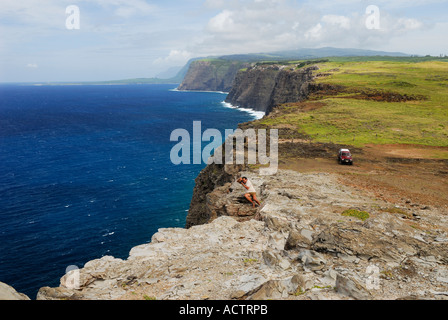 Un touriste de prendre une photo au bord de falaises de l'île de Molokai Hawaii Banque D'Images