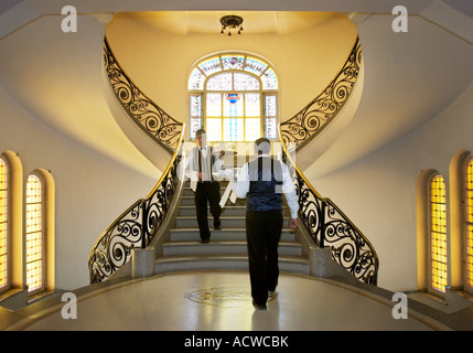 Deux serveurs avec l'argenterie de bacs de face d'un grand escalier Banque D'Images