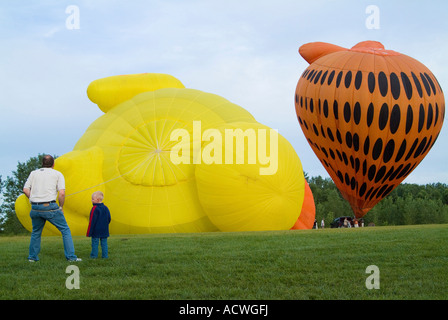 Un homme ET UN ENFANT SONT À REGARDER LES BALLONS À AIR S'APPRÊTE À DÉCOLLER Banque D'Images