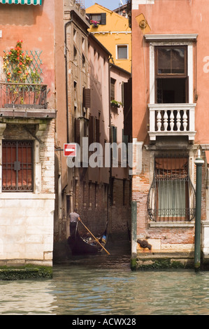 Verticale de l'image couleur d'un gondolier en descendant un petit canal latéral à proximité du Grand Canal à Venise Italie Banque D'Images