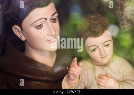 Détail de la statue de culte catholique romain de Taormina en Sicile avec l'enfant Jésus dans les bras de monk se tenant la main en geste de bénédiction Banque D'Images