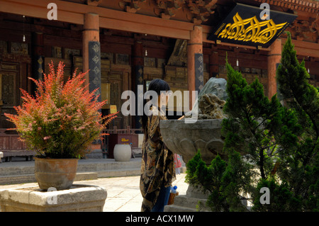 Une jeune femme se tient devant la salle de prière dans la Grande Mosquée de Xian Banque D'Images