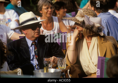 Couple heureux au tennis de Wimbledon Londres SW19 années 1980. Habillé avec élégance, boire un verre et profiter de la vie. 1985 ROYAUME-UNI HOMER SYKES Banque D'Images