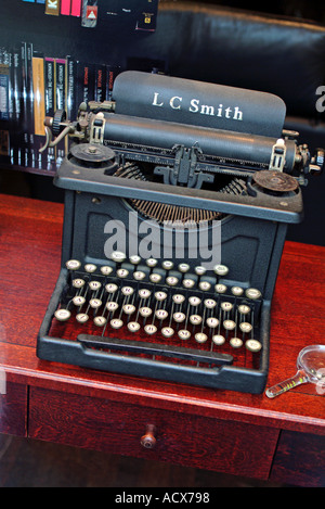 Voir d'antique machine à écrire sur le bureau en bois bureau à travers le verre storefront Banque D'Images