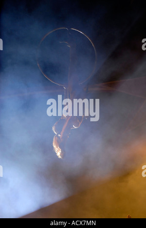 Artiste de cirque à l'aide de acrobat cerceau aérien aussi connu sous le nom de "Cerceau" ou "Lyra" un appareil d'acier circulaire Banque D'Images