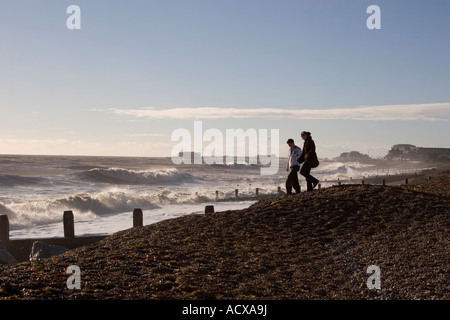 Un jeune couple marche main dans la main sur Worthing Beach West Sussex en hiver. Photo par Nikki Attree Banque D'Images