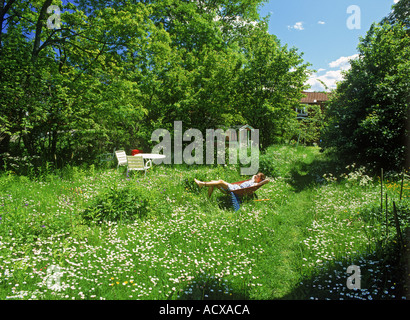 Swedish girl resting en brouette dans le jardin de fleurs sauvages appelé bellis Banque D'Images