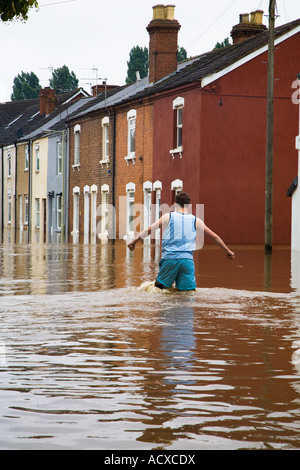 Garçon marchant à travers les inondations à Gloucester, Royaume-Uni Banque D'Images