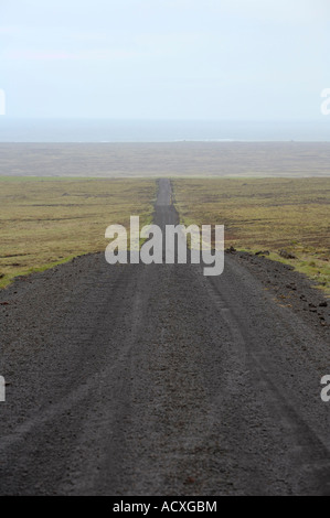 Un petit black Road en direction de l'océan atlantique et de disparaître derrière une colline près de Reykjavik, Islande Banque D'Images