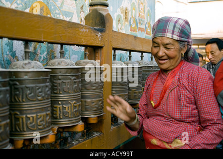 Femme de tourner les roues de prière tibétain.Bodhnath Stupa.La vallée de Katmandou au Népal. Banque D'Images