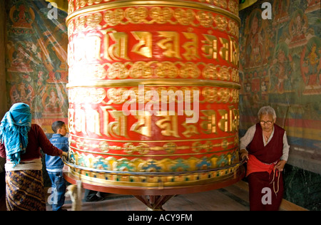 Pèlerins tibétains de tourner une grande roue de prière.Tsamchen Gompa.Bodhnath Stupa.La vallée de Katmandou au Népal. Banque D'Images