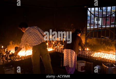 Éclairage lampes à beurre pèlerins.Tsamchen Gompa.Bodhnath stupa.Népal Banque D'Images