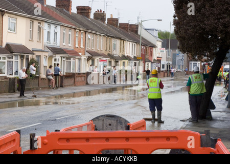 Aider les résidents nettoyer après une rafale d'eau les inondations leur maison lors d'une interdiction d'arrosage à Swindon Wiltshire Banque D'Images