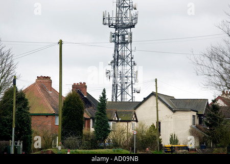 Un mât de téléphonie mobile à côté de maisons à Romsley UK Worcestershire Banque D'Images