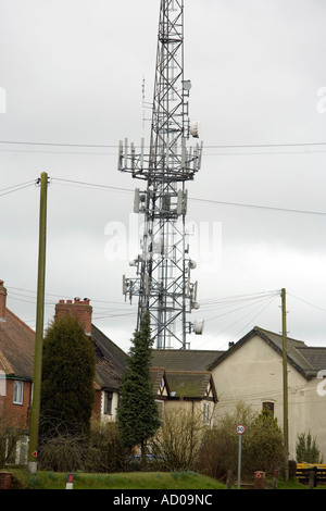 Un mât de téléphonie mobile à côté de maisons à Romsley UK Worcestershire Banque D'Images