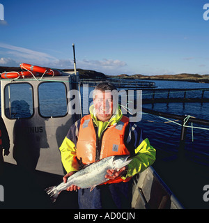 Angus Mcmillian appuie fièrement l'un de ses saumons d'organiquement capturé dans les eaux cristallines de la côte de Ni Banque D'Images