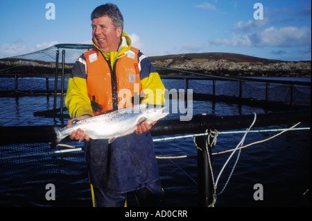 Angus Mcmillian appuie fièrement l'un de ses saumons d'organiquement capturé dans les eaux cristallines de la côte de Ni Banque D'Images