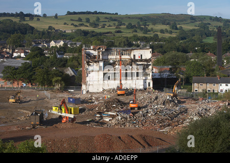 Vue en hauteur du site de démolition (coque d'usine vide, pelles hydrauliques à chenilles lourdes travaillant et démolissant des bâtiments, piles de gravats) - Guiseley, Angleterre, Royaume-Uni. Banque D'Images