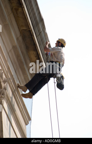 Descente en rappel du travailleur sur le devant de l'Hôtel de ville de Sheffield pour fixer à façade bannière Banque D'Images