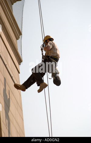 Descente en rappel du travailleur sur le devant de l'Hôtel de ville de Sheffield pour fixer à façade bannière Banque D'Images