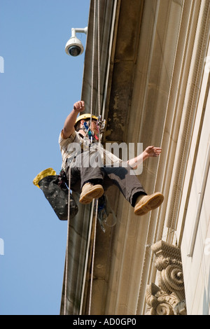 Descente en rappel du travailleur sur le devant de l'Hôtel de ville de Sheffield pour fixer à façade bannière Banque D'Images