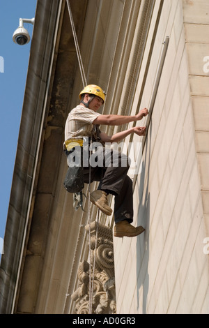 Descente en rappel du travailleur sur le devant de l'Hôtel de ville de Sheffield pour fixer à façade bannière Banque D'Images