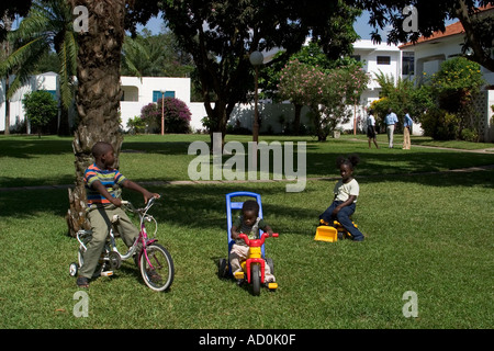 Les enfants africains locaux jouant à l'extérieur de la maison du développement de l'habitation avec les parents en arrière-plan Accra Ghana Banque D'Images