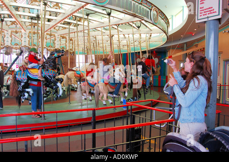 Merry go round manège construit en 1911 par Charles I D Looff au Boardwalk de Santa Cruz Ca - maman et grand-mère fils photographie Banque D'Images