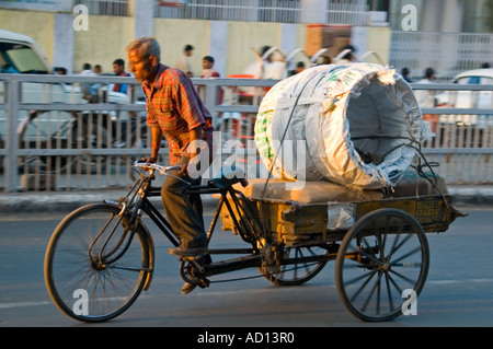 Vue horizontale d'un scènederue indien typique avec un Indien chargé de son vélo-pousse à travers les rues de la vieille ville de Delhi Banque D'Images