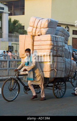 Vue verticale d'une scènederue avec un indien en poussant son rickshaw surchargé par de vieux Delhi Banque D'Images