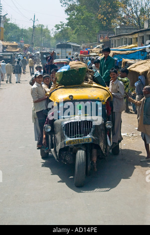 Close up vertical humoristique d'Indiens coincée dans un vieux pousse-pousse sur la route. Banque D'Images