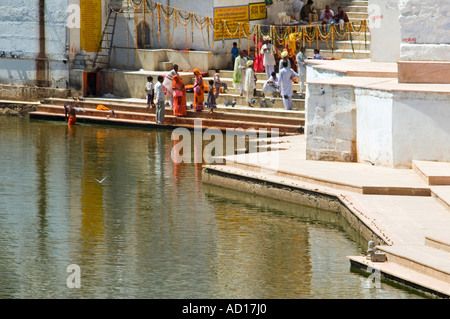 Grand angle de vue horizontale surélevée des Indiens vêtus de saris colorés sur les ghats au lac Pushkar. Banque D'Images