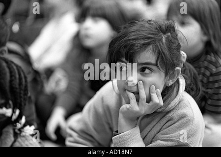 Jeune fille écoute attentivement à une histoire en cours de lecture à une bibliothèque publique de New York à New York City Banque D'Images