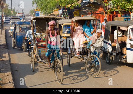 Une scène de rue chaotique typique à Varanasi avec randonnée et auto rickshaws (Tuk Tuks) sur les rues animées. Banque D'Images