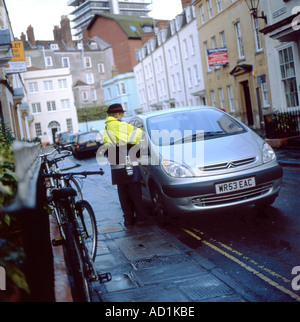 Femme femme gardien de la circulation écrivant un billet de stationnement amende pénalité pour voiture garée dans la rue Bristol en Angleterre Grande Bretagne Grande Bretagne KATHY DEWITT Banque D'Images