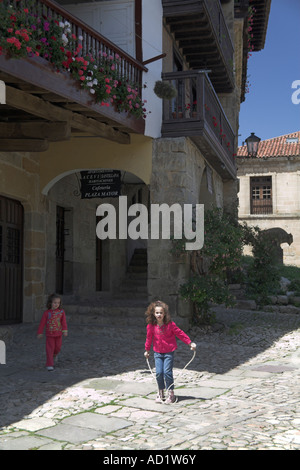 Les filles sautant par maisons anciennes Santillana del Mar Cantabrie au Nord de l'Espagne Banque D'Images