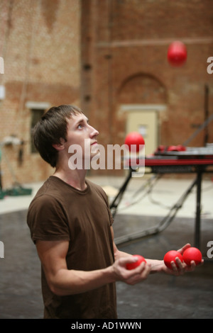 Un homme jongle avec des balles au cours de la pratique à l'école de cirque à Londres Banque D'Images