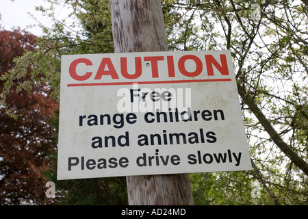 Attention free range les animaux et les enfants signe de la circulation dans le village de Cotswold UK Banque D'Images