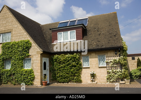 Trois panneaux solaires thermiques modernes avec tubes sous vide sur le toit de maison individuelle Cotswolds UK Banque D'Images