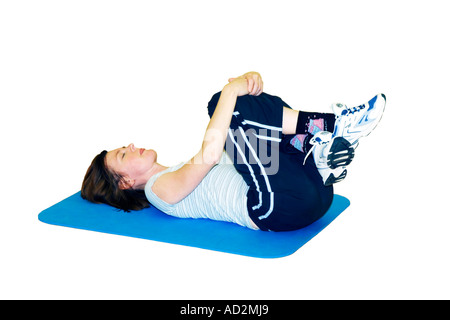 Les femmes adultes d'effectuer des exercices d'étirement sur un tapis placé sur un fond blanc Banque D'Images