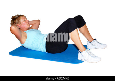 Solitaire adulte femme exécutant Sit UPS tapis d'exercice sur un fond blanc Banque D'Images