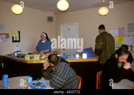 Des religieuses au service de repas dans une soupe populaire pour le bas et les aboutissants, Londres. Banque D'Images